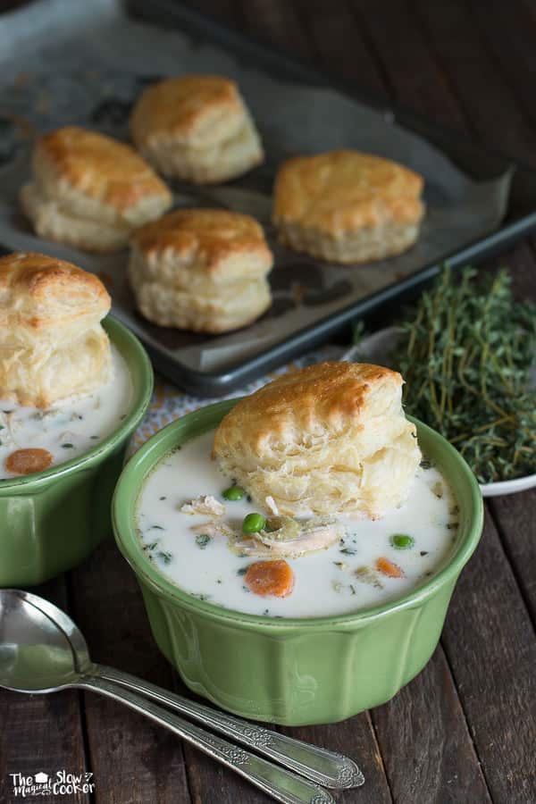 a green bowl of chicken pot pie soup with puff pastry biscuit on top.