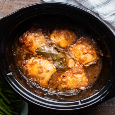 chicken adobo cooked in slow cooker with bay leaves on top.