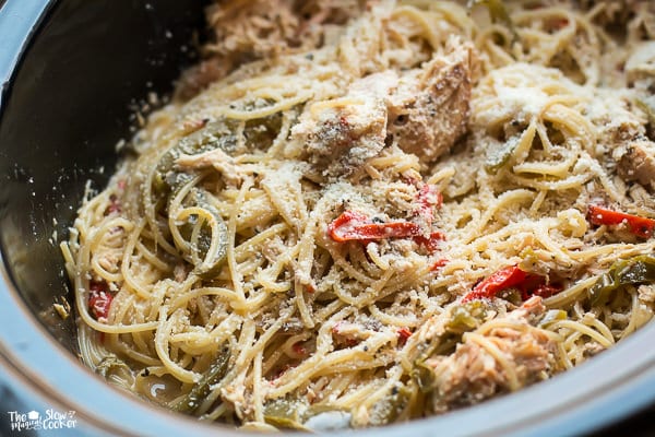 chicken spaghetti with parmesan cheese on top in slow cooker