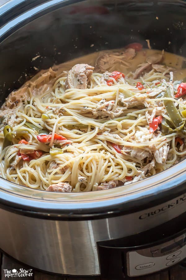 spaghetti in slow cooker in creamy sauce with chicken and peppers.