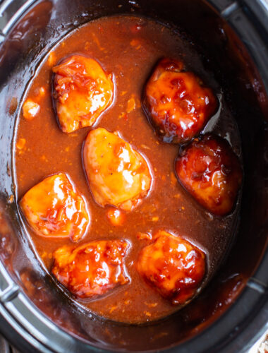 close up of chicken thighs with apricot sauce in slow cooker