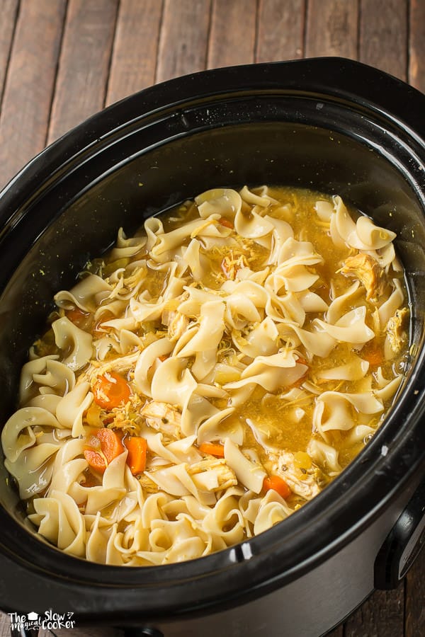 egg noodles, chicken broth, curry seasoning, and carrots in a slow cooker.