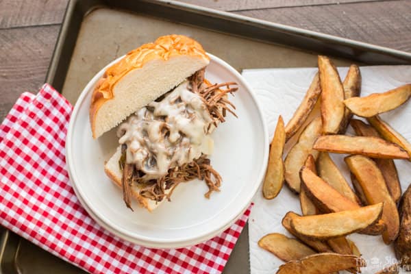 Shredded beef philly cheese steak with jo jo potatoes on side.