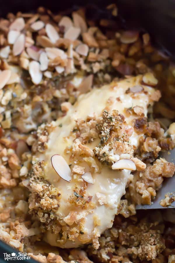 close up of chicken breast with stuffing and almonds on top.