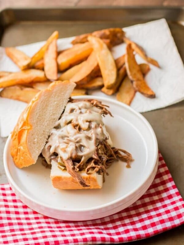 philly cheese steak sandwich on a plate with fries.