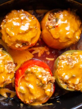 5 meatloaf stuffed peppers with cheese on top in slow cooker, in salsa