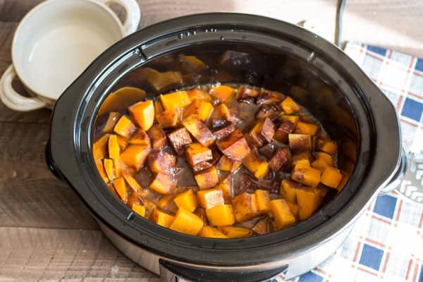 cooked cubed butternut squash with cinnamon on top. in the slow cooker.