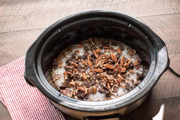 cake mix with coconut, chocolate chunks, and pecans on top.