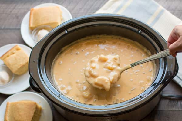 potato cheese soup on a ladle coming from a slow cooker.