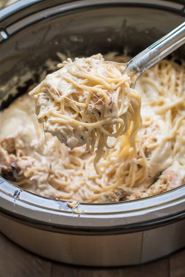 chicken tetrazzini on a ladle coming from a slow cooker.