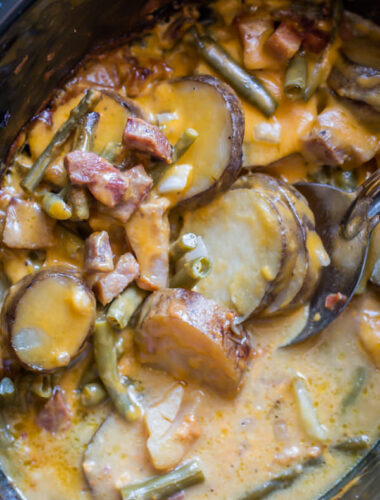 sliced potatoes, ham and green beans in a slow cooker.