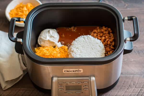 enchilada sauce, rice, pinto beans, cheese and sour cream in a slow cooker.