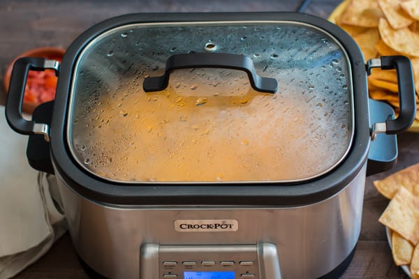 Enchilada dip in a slow cooker with a lid on in it.