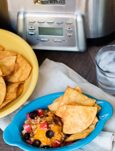 bowl of enchilada dip with chips on the side.