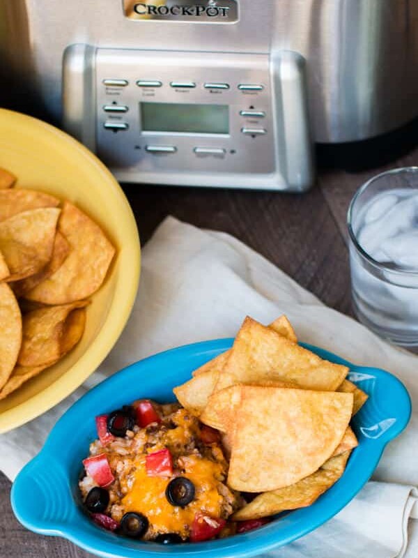 bowl of enchilada dip with chips on the side.