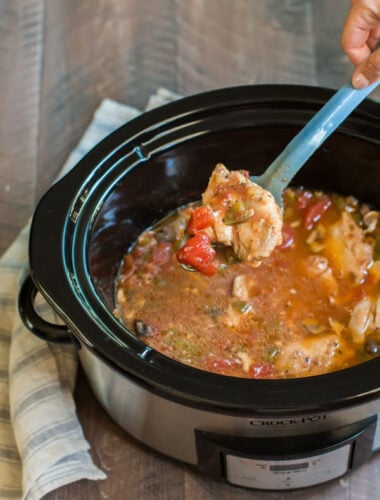 chicken cacciatore in a slow cooker with tomatoes and bell peppers.