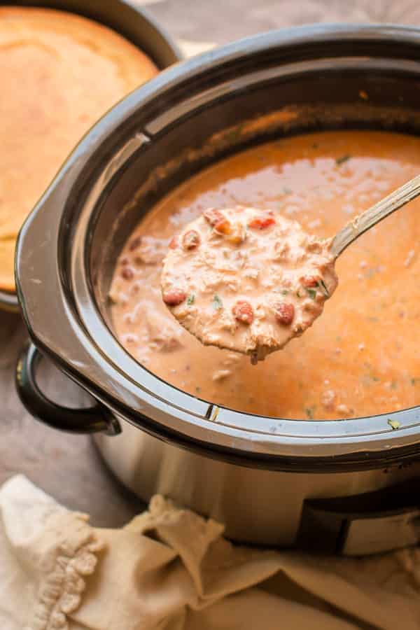 ladle of cream cheese chicken chili coming from a slow cooker.