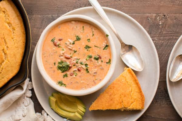 cream cheese chicken chili in a bowl with wedge of cornbread