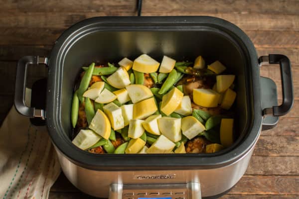 chicken thighs with squash and snow peas in a slow cooker.