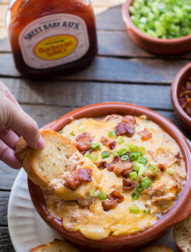 bread scooping barbecue chicken dip from a bowl.