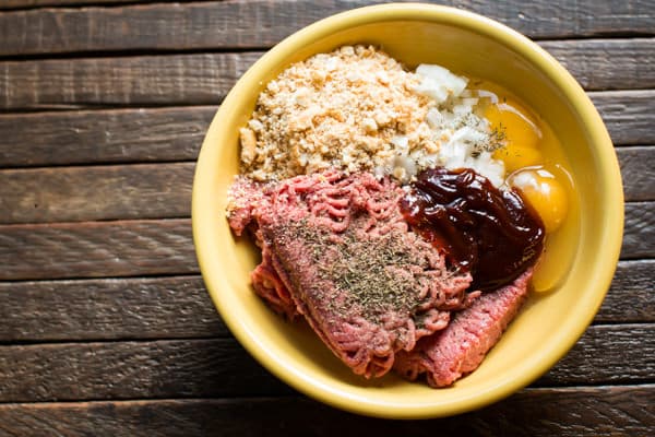 ground beef, bread crumbs, barbecue sauce, eggs and onion in a bowl.