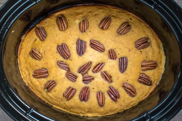 cooked pumpkin cake with pecans in a slow cooker.
