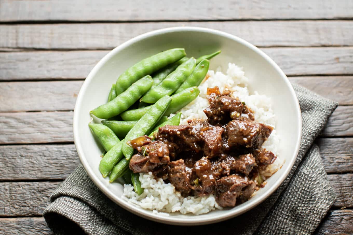 bowl with rice, teriyaki beef and snow peas