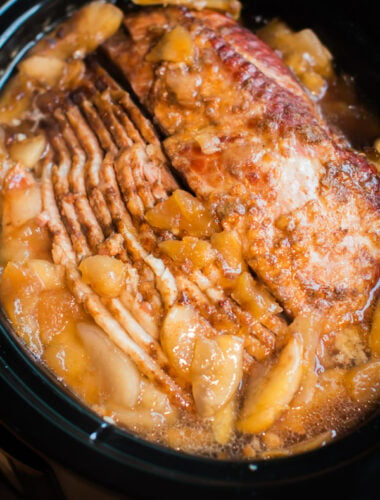 close up of spiral ham in the slow cooker with cloves and apple pie filling