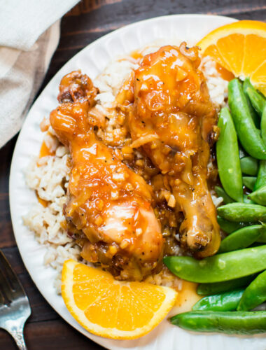 orange chicken drumsticks on rice on a plate