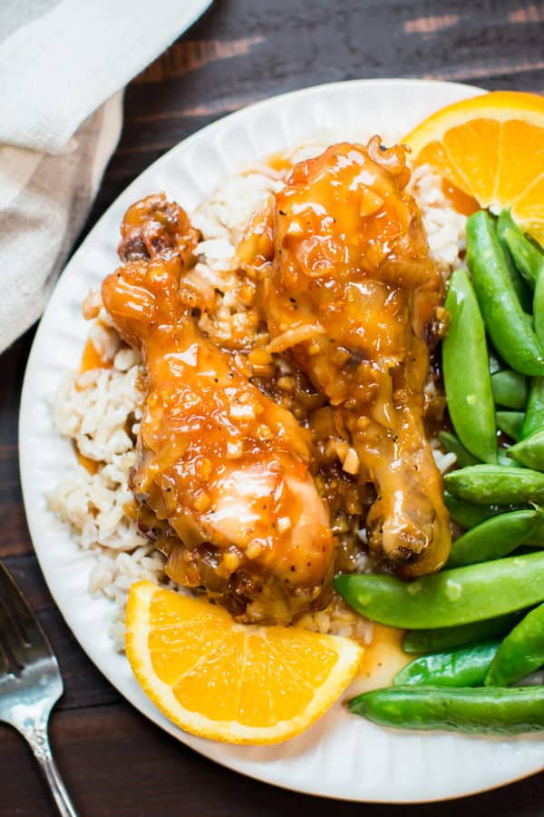 orange chicken drumsticks on rice on a plate