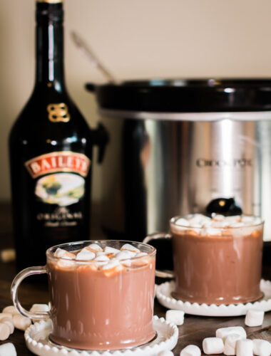 2 cups of baileys hot chocolate with bottle of baileys behind it.