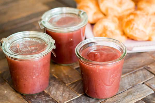 3 jars of cranberry apple butter on a table.