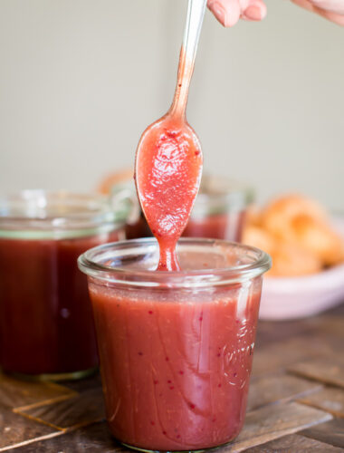 spoon coming out of jar of cranberry apple butter.