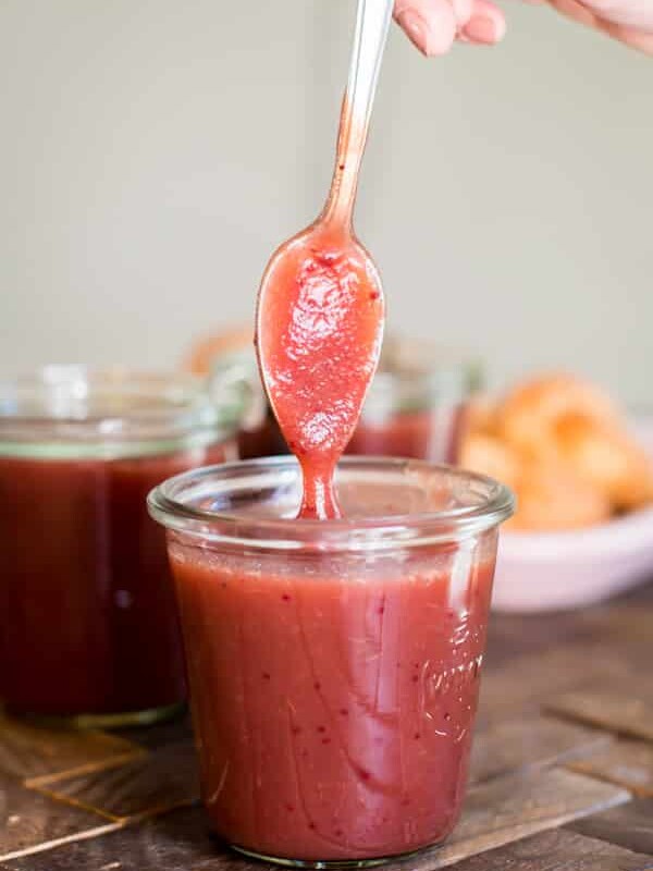 spoon coming out of jar of cranberry apple butter.