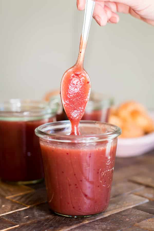 spoon coming out of jar of cranberry apple butter.