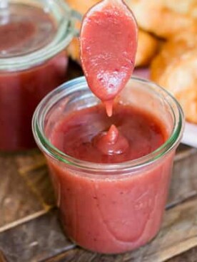 cranberry apple butter with spoon coming out of it.