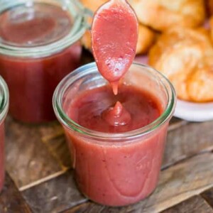 cranberry apple butter with spoon coming out of it.