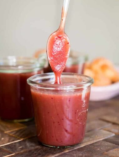 cranberry apple butter in a jar with a spoon.