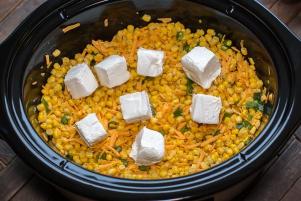 corn in cheese and jalapenos with cream cheese cubes on top.