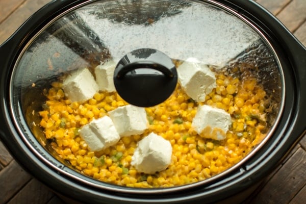 Slow cooker with cooking creamy jalapeno corn in it.