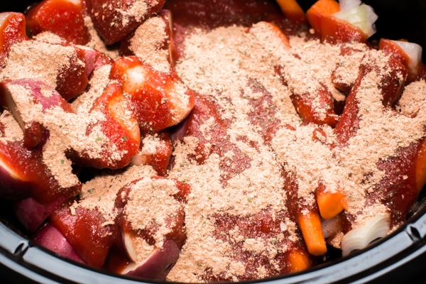 roast with red potatoes and carrots with spaghetti seasoning on top.