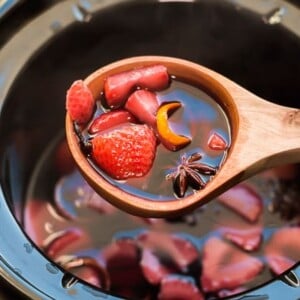 scoop of mulled strawberry wine from the slow cooker.