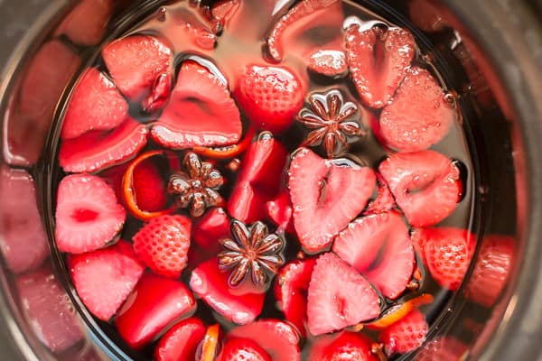 close up of strawberries in mulled wine in slow cooker.