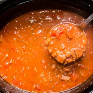 beef enchilada chili on a ladle coming from the slow cooker.