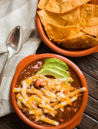 bowl of enchilada chili with cheese and avocado
