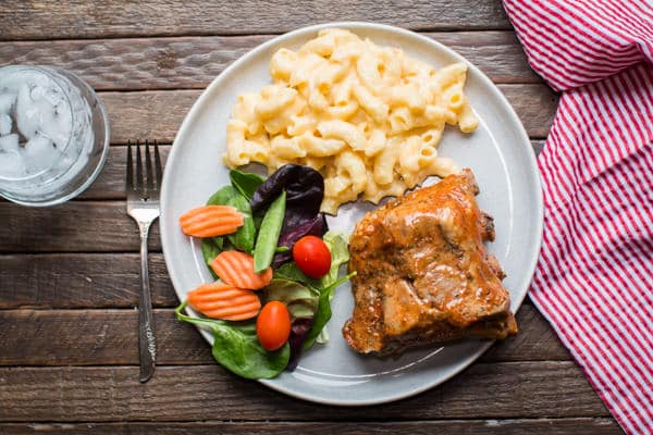 ribs, mac and cheese, and salad on a plate.