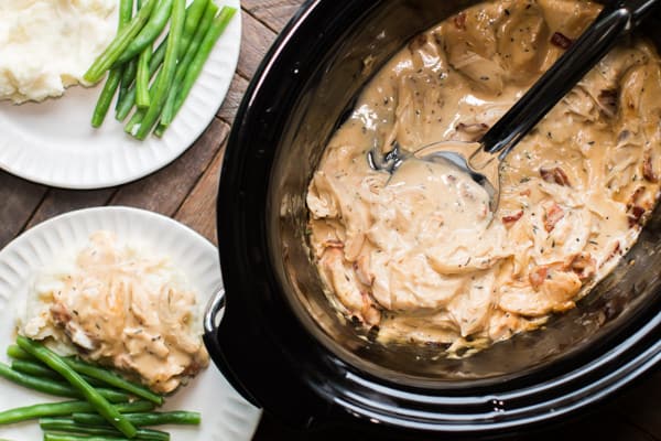 shredded chicken and gravy with a spoon in it.