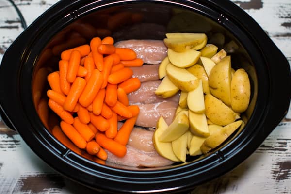 raw carrots, potatoes and yukon gold potaotes in a slow cooker.