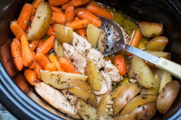 cooked potatoes, carrots and chicken mixed together in a slow cooker.