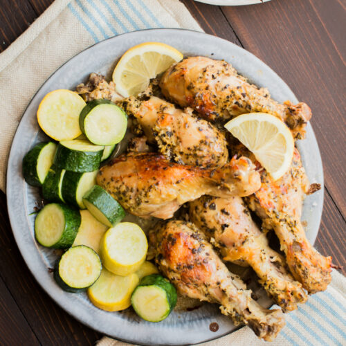 greek chicken thighs on a pie tin with squash.